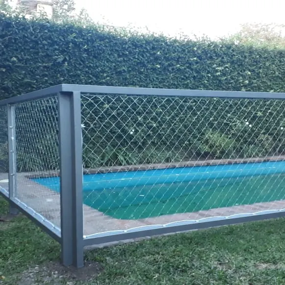 Cerco de pileta con estructura metálica gris y red en el jardín.
