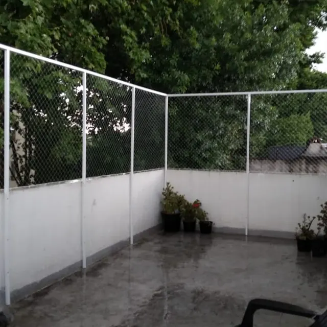 Terraza blanca con red en todo el perímetro.