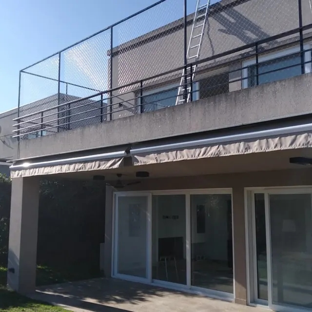 Terraza de una casa con estructura y red sobre el borde.